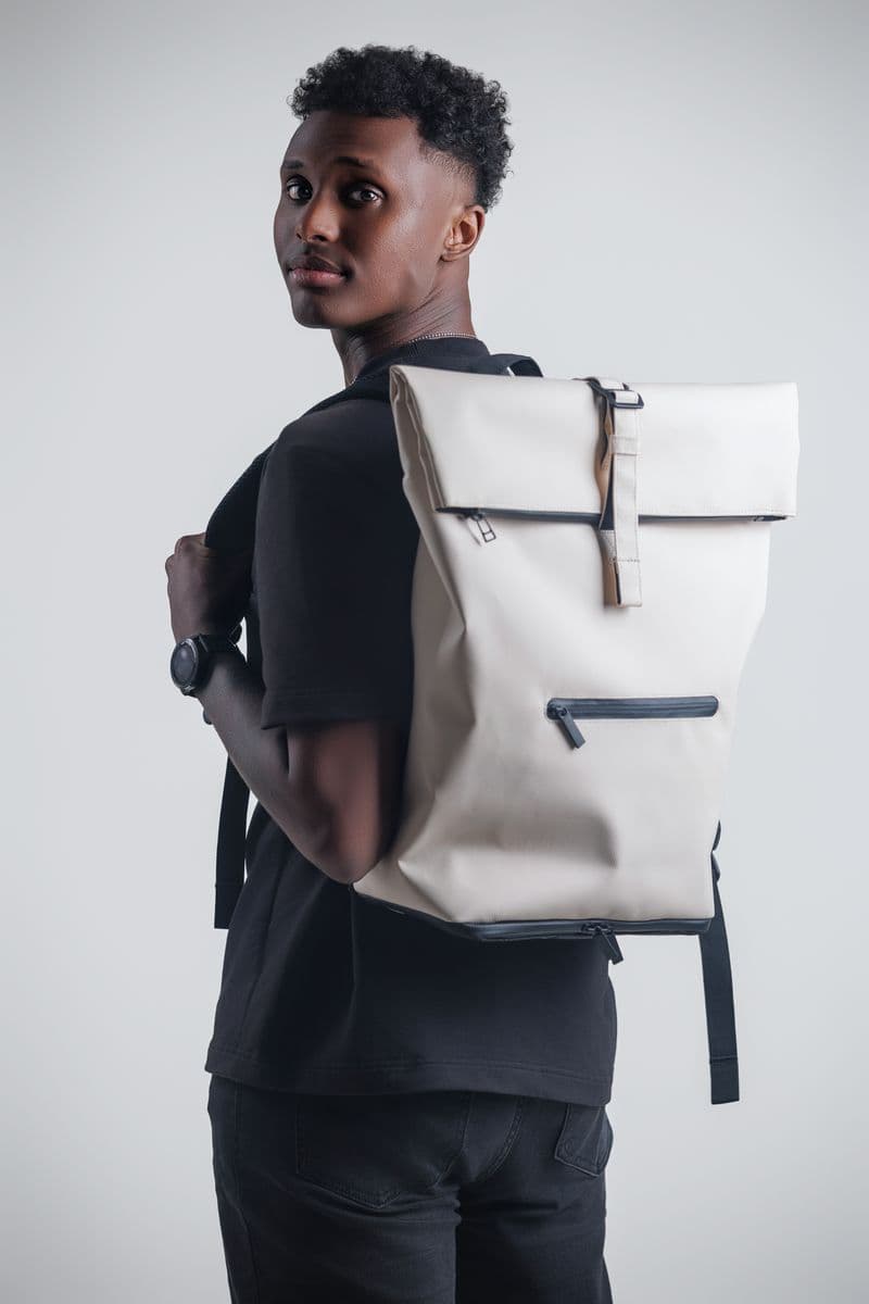 Model wearing NORJ white backpack, looking over shoulder