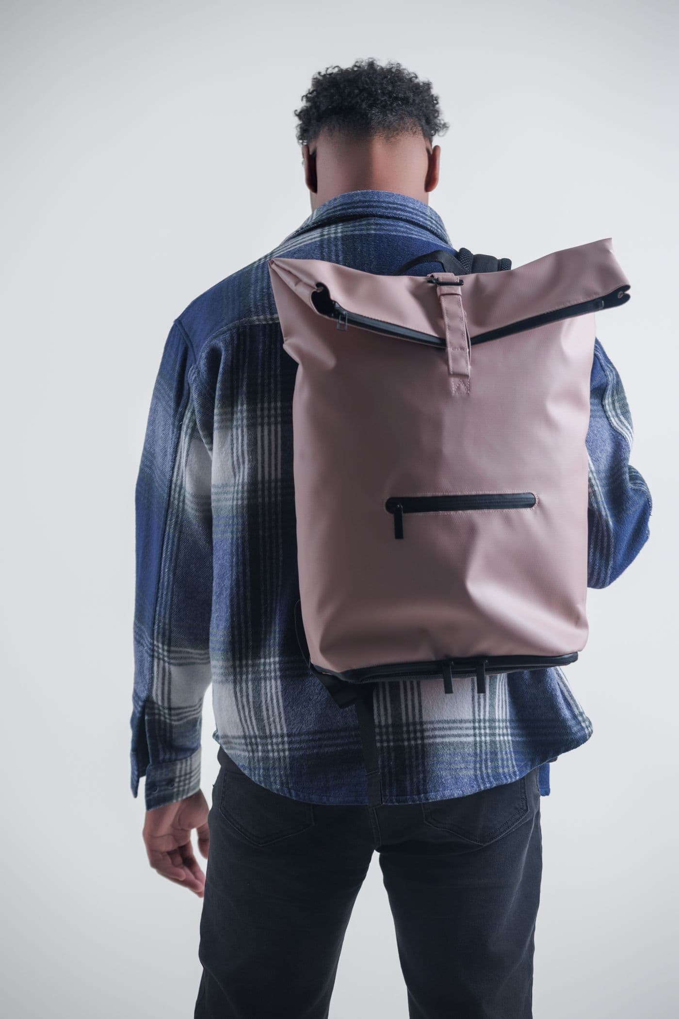 Model wearing NORJ pink backpack with flannel jacket
