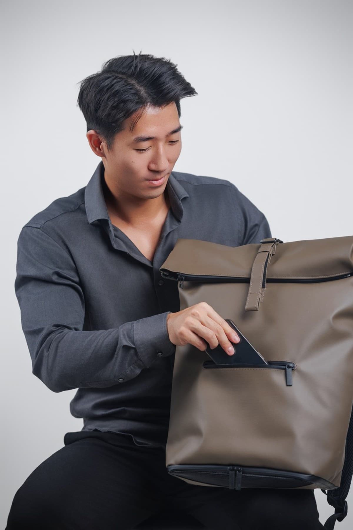 Model sliding tablet into NORJ backpack front pocket